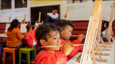 Twee kinderen zijn aan het schilderen in de Kunstwerkplaats in het Mauritshuis.